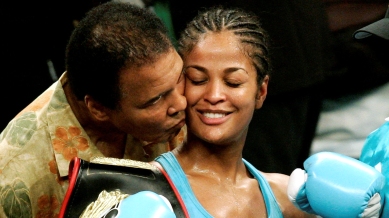 WBC and WIBA super middleweight champion Laila Ali is kissed by her father, boxing great Muhammad Ali, at the MCI Center in Washington in this June 11, 2005 file photo.